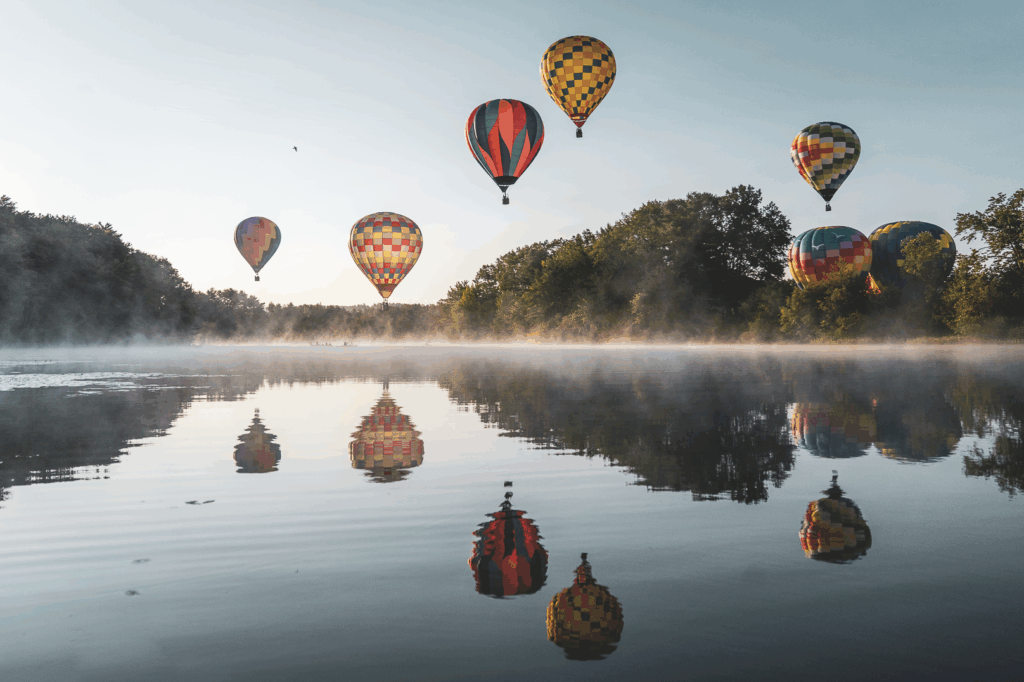 Landscape with 6 hot air balloons over the misty river and trees